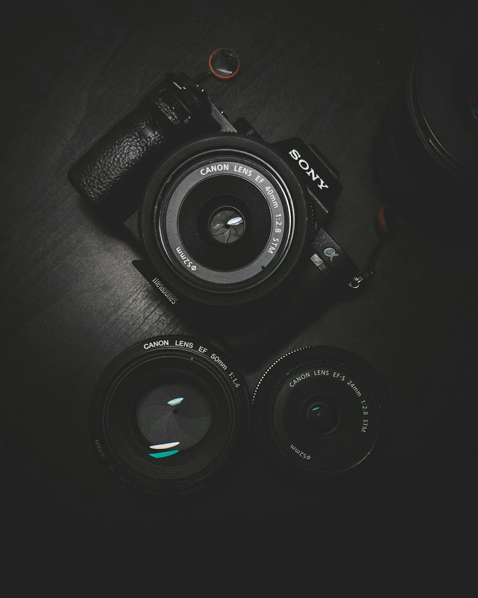 Mirrorless camera body and lenses on a dark surface