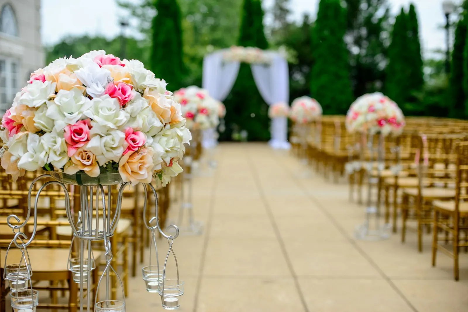 Outdoor ceremony aisle lined with floral arrangements