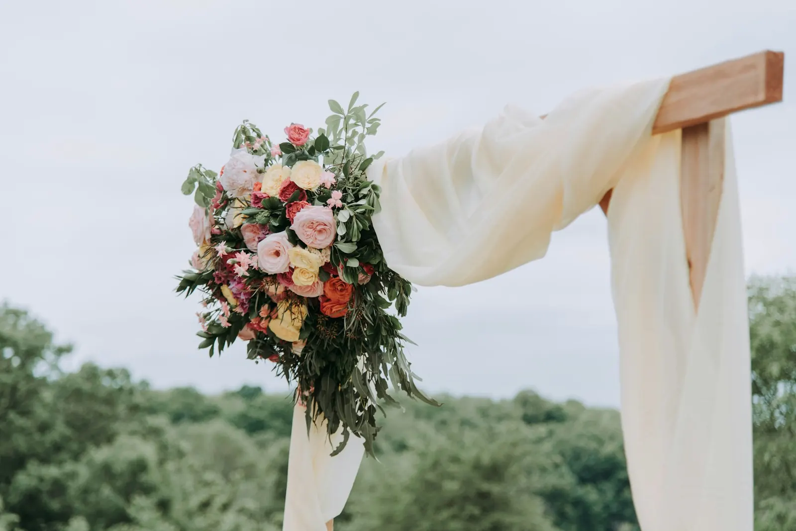 Wedding arch draped in linen and garden roses