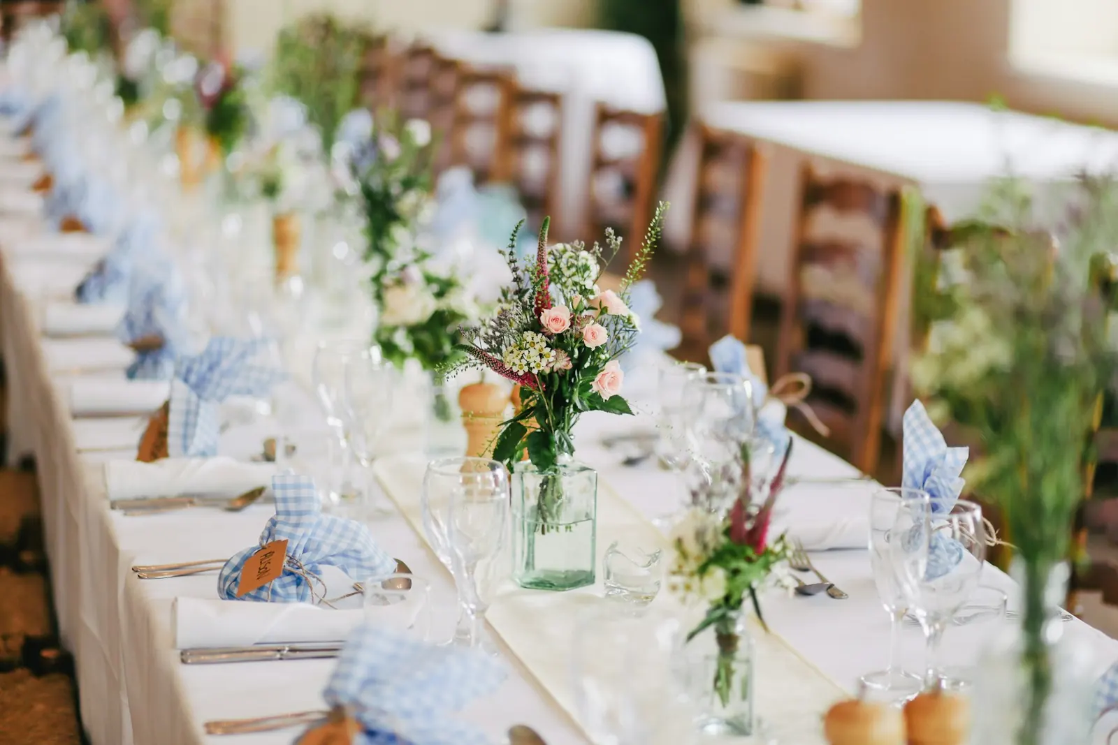 Long reception table with wildflowers and glassware